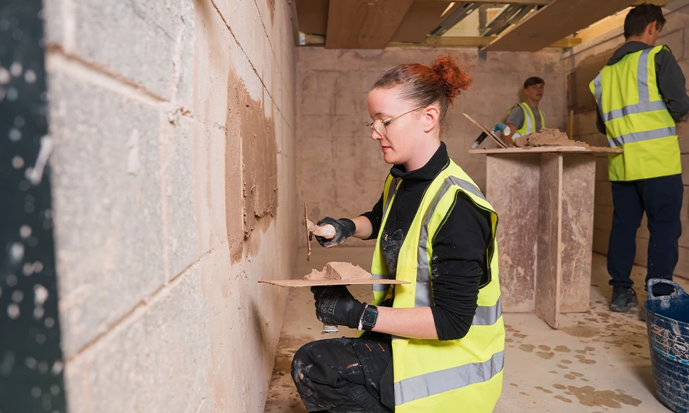Construction student working inside plastering workshop